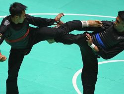 Pesilat Indonesia Komang Harik Adi Putra (kiri) melepaskan tendangan ke arah pesilat Malaysia Mohd Al Jufferi Jamari (kanan) dalam babak final Kelas E Putra Asian Games 2018 di Padepokan Pencak Silat Taman Mini Indonesia Indah (TMII), Jakarta, Senin (27/8). ANTARA FOTO/INASGOC/Melvinas Priananda/nak/18.