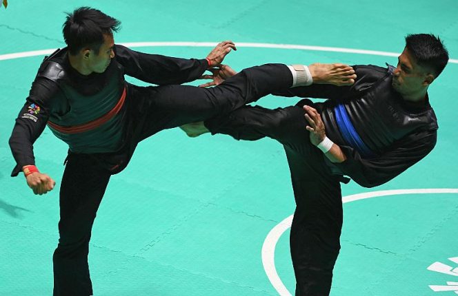 
					Pesilat Indonesia Komang Harik Adi Putra (kiri) melepaskan tendangan ke arah pesilat Malaysia Mohd Al Jufferi Jamari (kanan) dalam babak final Kelas E Putra Asian Games 2018 di Padepokan Pencak Silat Taman Mini Indonesia Indah (TMII), Jakarta, Senin (27/8). ANTARA FOTO/INASGOC/Melvinas Priananda/nak/18.
