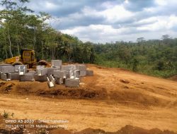 Alat berat Wales stump dan excavator sedang beraktivitas pada pembangunan Embung di Malang, Jawa timur