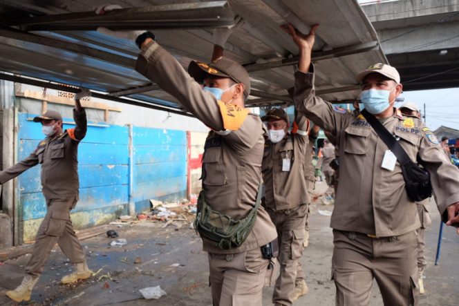 
					Personel Satpol PP Kota Depok saat melakukan penertiban bangunan pedagang di sisi barat bawah Jembatan Fly Over Arif Rahman Hakim (ARH). (Dok. Diskominfo Depok)