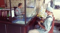 Ka SPKT Polsek Buduran Siput Sukarman Hadi saat memberikan pelayanan pada masyarakat di hari Minggu.