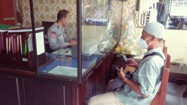 Ka SPKT Polsek Buduran Siput Sukarman Hadi saat memberikan pelayanan pada masyarakat di hari Minggu.