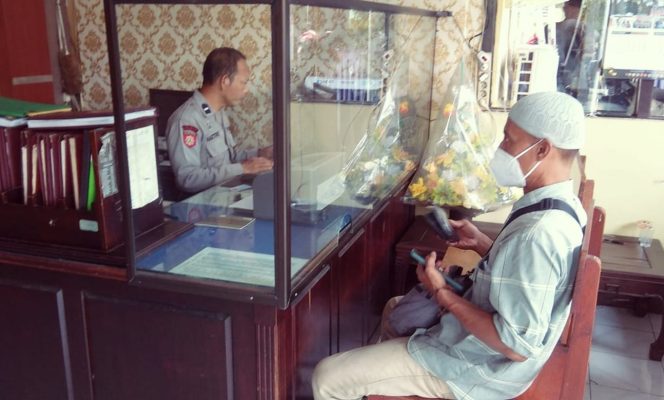 
					Ka SPKT Polsek Buduran Siput Sukarman Hadi saat memberikan pelayanan pada masyarakat di hari Minggu.