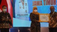 Gubernur Jatim Khofifah Indar Parawansa Saat menyerahkan Piagam Penghargaan ke Kadisnakertrnas Jatim Dr Himawan Estu Bagijo