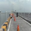 Tampak pekerja PT Radjendra Pratama jaya sedang beraktivitas melaksanakan pekerjaan coating mikron dinding barrier jalur sepeda motor Jembatan Suramadu sisi Gresik