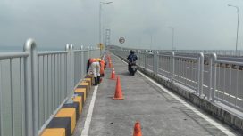 Tampak pekerja PT Radjendra Pratama jaya sedang beraktivitas melaksanakan pekerjaan coating mikron dinding barrier jalur sepeda motor Jembatan Suramadu sisi Gresik