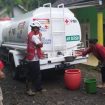 PMI Banyuwangi saat  melakukan Pendistribusian bantuan air bersih dengan menggunakan truk tangki pada warga  terdampak banjir di Dusun Gumukcandi Desa Songgon Kabupaten Banyuwangi (26/11/21).