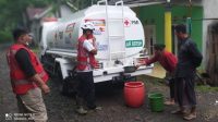 PMI Banyuwangi saat melakukan Pendistribusian bantuan air bersih dengan menggunakan truk tangki pada warga terdampak banjir di Dusun Gumukcandi Desa Songgon Kabupaten Banyuwangi (26/11/21).