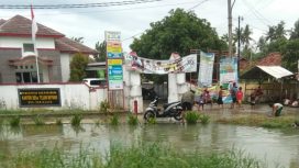 Kantor Desa Telukbuyung dan Jalan Raya digenangi luapan air irigasi.