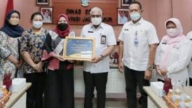 Komisioner KI Provinsi Jatim saat menyerahkan piagam penghargaan kepada Kepala Dinsos Provinsi Jatim di ruang rapat pimpinan Dinsos Jatim, Rabu (22/12/2021).