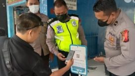 Salah satu pengunjung pantai Camplong Sampang sedang melakukan scan Peduli Lindungi