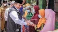 Bupati Jember, Hendy Siswanto (kiri) sedang membagikan tali asih kepada warga Tempurejo.(6/4/22).