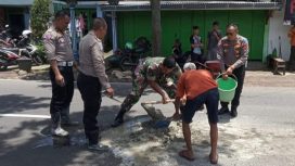 Polisi bersama TNI dibantu warga menambal jalan berlubang di dekat jembatan Tunggulmas Kecamatan Lowokwaru kota Malang
