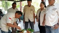Pembina DPD SWI kabupaten Sidoarjo Joni, SE, saat memotong tumpeng untuk diberikan kepada ketua DPD SWI Sidoarjo NC Suherman SH