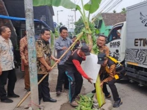 Kepala Dinas PU Bina Marga dan Sumber Daya Air Dwi Eko dan Kadis Perkim Moch Bahruni Aryawan bersihkan pohon pisang yang di tanam warga di tengah jalan yang rusak di Dusun Keling Sukodono.