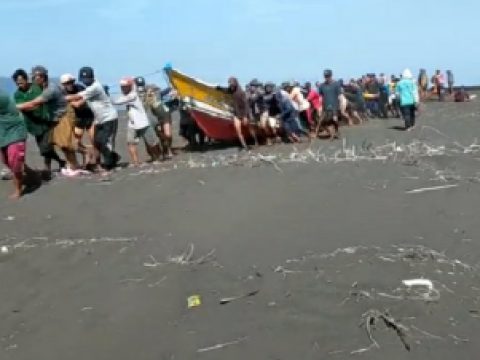 Warga Nelayan sedang melakun penarikan bankai perahu yang karem ke daratan