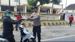 Aipda Samsul Arifin, bagikan nasi kotak kepada warga pengendara motor yang kebetulan melintas di depan kantor Polsek Puger