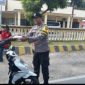 Aipda Samsul Arifin, bagikan nasi kotak kepada warga pengendara motor yang kebetulan melintas di depan kantor Polsek Puger