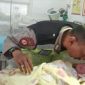 Polisi RW bersama bayi yang dilematkannya