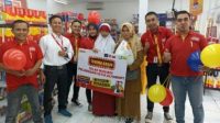 Kru Alfamart saat foto bersama dengan salah satu Konsumen yang mendapatkan Voucher belanja Gratis