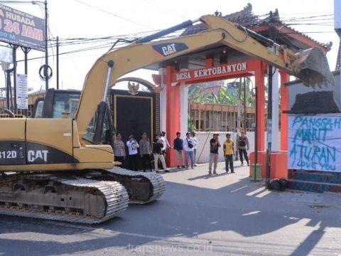 Pembongkaran Tugu perguruan silat PSHT oleh Warga dengan menggunakan Excavator di depan pintu Gerbang jalan Sultan Agung Desa Kertobanyon, Madiun, Jum'at (5/9/2023)
