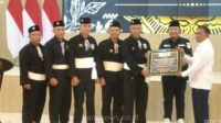 Perwakilan Perguruan pesilat PSHT saat serakan bantuan ke PMI di saksikan Bupati Jember