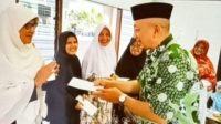 Hafid Nasir terlihat tengah membagikan amplop kepada ibu-ibu di sebuah tempat ibadah. Foto: Tangkapan Layar Video/TransNews