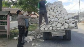 Aipda Samsul sedang membantu menurunkan batu kapur