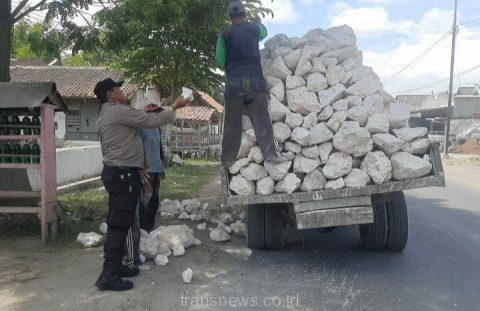 Aipda Samsul sedang membantu menurunkan batu kapur