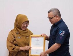 Pj.Sekda Kota Depok, Nina Suzana menyerahkan penghargaan kepada Dirut Tirta Asasta, M.Olik Abdul Holik.
