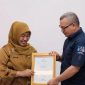 Pj.Sekda Kota Depok, Nina Suzana menyerahkan penghargaan kepada Dirut Tirta Asasta, M.Olik Abdul Holik.