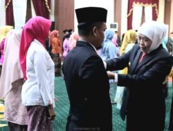 Gubernur Jatim, Khofifah saat menyematkan lencana Satyalancana Karya Satya kepada salah satu ASN di Grahadi, Surabaya, Senin (18/8/2025). .