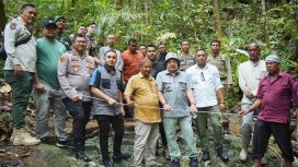 Bupati Nagan Raya Teuku Raja Keumangan dan romboongan berdiri di atas batu giok 5000 ton yang baru ditemukan. (Diskominfo.Nara)