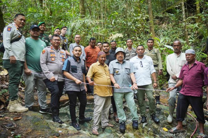 
					Bupati Nagan Raya Teuku Raja Keumangan dan romboongan berdiri di atas batu giok 5000 ton yang baru ditemukan. (Diskominfo.Nara)

