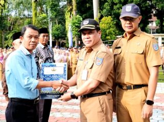Sekretaris Daerah (Sekda) Kota Depok, Mangnguluang Mansur menyerahkan Surat Keputusan (SK) Pensiun dan bantuan dari Korps Pegawai Republik Indonesia (KORPRI) Kota Depok.  (dok.Humas dan Prokopim Depok).