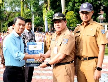 Sekretaris Daerah (Sekda) Kota Depok, Mangnguluang Mansur menyerahkan Surat Keputusan (SK) Pensiun dan bantuan dari Korps Pegawai Republik Indonesia (KORPRI) Kota Depok.  (dok.Humas dan Prokopim Depok).