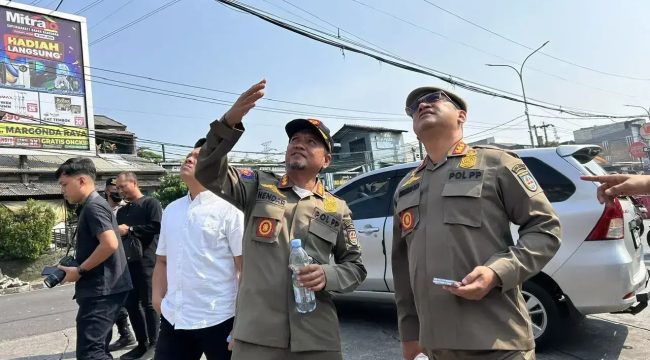 Satuan Polisi Pamong Praja (Satpol PP) melakukan penertiban  membongkar tiang reklame di kawasan Jalan Raya Citayam-Grand Depok City (GDC).