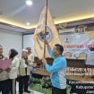 Ketua Umum SWI Iskandar, S.Sos. mengibarkan Bendera Pataka SWI usai dilantik pada Munas SWI 2026.