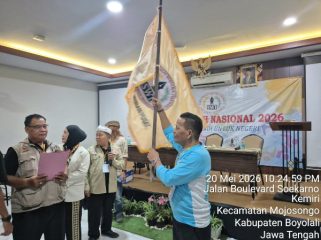 Ketua Umum SWI Iskandar, S.Sos. mengibarkan Bendera Pataka SWI usai dilantik pada Munas SWI 2026.