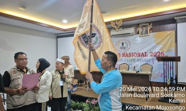 Ketua Umum SWI Iskandar, S.Sos. mengibarkan Bendera Pataka SWI usai dilantik pada Munas SWI 2026.